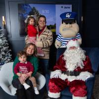 Parents with boy and girl smile with Santa and Louie